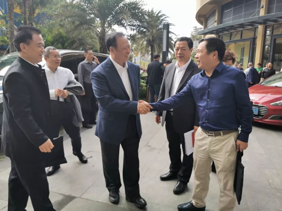 中国施工企业管理协会会长曹玉书与南海区建筑业协会会长周泳锋握手问候